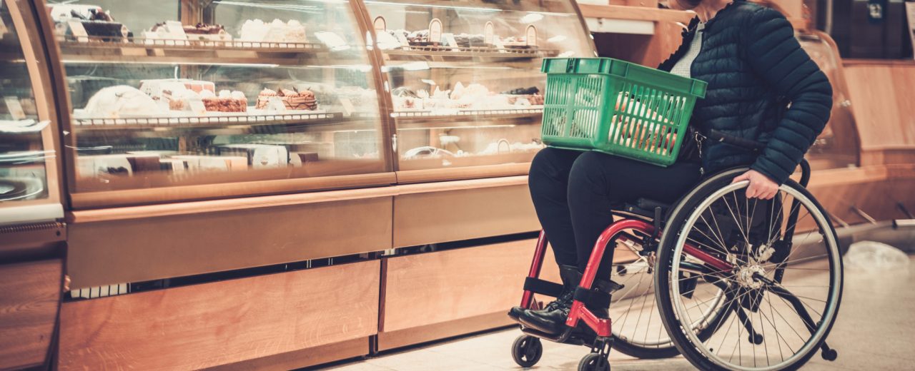 Personne faisant des courses au supermarché en fauteuil roulant