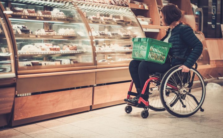 Personne faisant des courses au supermarché en fauteuil roulant